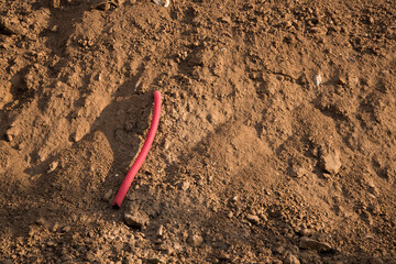 Sewer pipe removed from the ground during the construction phase. Cable channel, taken out from under the building under construction. Construction site. Red corrugated pipe