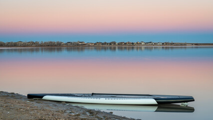 dusk over lake in Colorado with a stand up paddleboard on a beach, Boyd Lake State Park