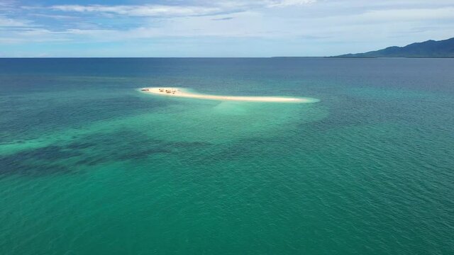 Cinematic shot , aerial view of a small Island, a sand bar in Roxas, Palawan. Summer and travel vacation concept. Tropical islands, top view.Seascape with beautiful sky and islands. Turquoise sea with