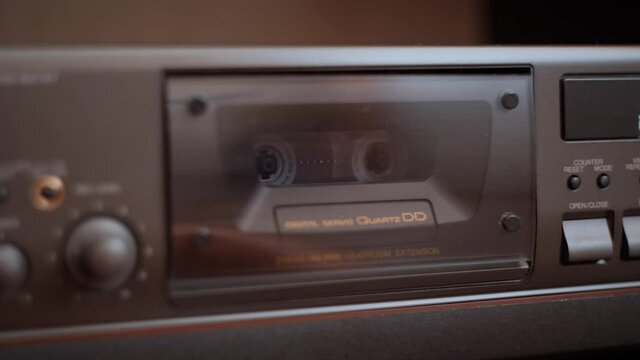 Audio cassette is spinning in a tape recorder