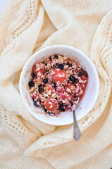 a plate of oatmeal with berries and cup of coffee