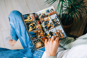 Fototapeta premium Man reads comic book in living room at home. Rostov-on-Don, Russia. 8 September 2021