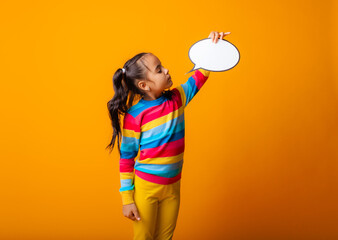 portrait of a little girl holding an empty paper cloud pondering an idea.