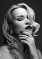 Obraz premium Beautiful sexy woman with vintage make-up and hairstyle. Diva of cinematograph in black and white noir. American style