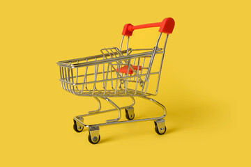 Empty mini shopping basket isolated on yellow background. Retail.