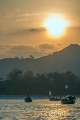 A summer day dawns on Kata beach with long tails boats moored in the water