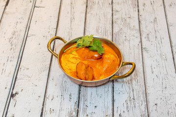 Sweet chicken tikka masala curry in traditional metal container from hindus restaurants