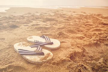 Flip-flops on a sandy beach of sea.