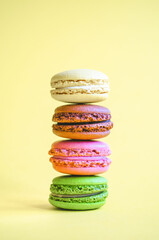 Many colorful macaroon on a pastel yellow background. Copy space. Space for text