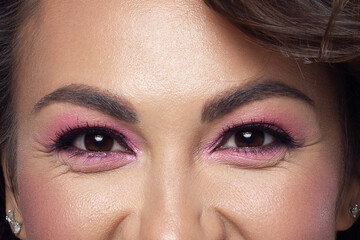Elegance close-up female eye with light pink eyeshadow. Macro shot of part of the face of a beautiful woman. Wellness, cosmetics and makeup. smooth beautiful eyebrows and eyelashes
