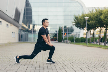 Fototapeta na wymiar Male asian athlete doing fitness in the morning near the stadium