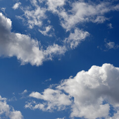 Blue sky with white clouds backlit by sunlight