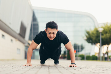 Male asian athlete doing fitness in the morning near the stadium pushes off the ground rejoices