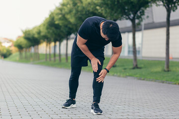 Asian man holding knee pain after running and fitness, severe leg pain