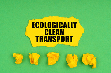 On a green background, crumpled yellow paper and a sheet with the inscription - Ecologically Clean Transport