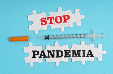 On a blue background, a syringe and puzzles with the inscription - STOP PANDEMIA
