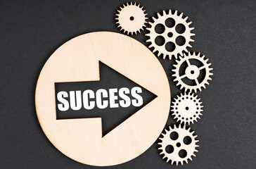 On a black background gears and a circle, inside the circle there is an arrow and an inscription - Success