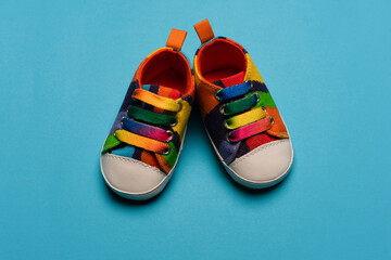 Denim sports shoes for baby, stands on a blue background. The concept of children's clothing. 
