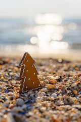 Small cookies in the form of a Christmas tree on the background of the sea. Vertical frame. Selective focusing.