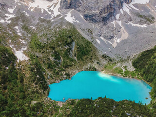 Aerial drone view of alpine turquoise water Sorapis Lake or Lago di Sorapis in Dolomites mountains, Italy