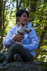 Woman with Jack Russel Terrier in a green forest