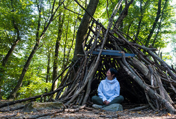 Woman survivalist in a campsite in the forest