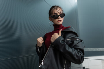 Beautiful future fashionable woman model in stylish sunglasses with black denim jacket and burgundy...