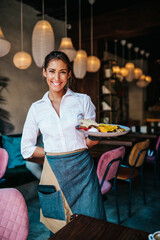 Beautiful young waitress serving delicious omelet. C