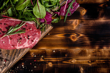 Raw meat steak with pepper and greens