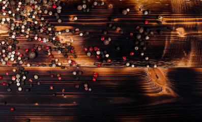 Big red, white and black pepper on a dark wooden table