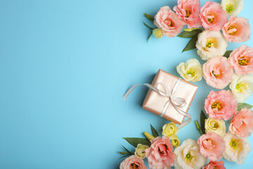flower arrangement and gift on colored background top view with place for text