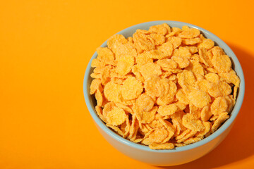 Delicious cornflakes in a plate against colored background. 
