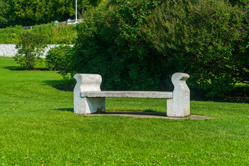 White empty concrete bench in a public park.