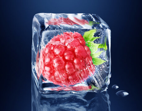 Raspberry in ice cube isolated on black, dark blue background