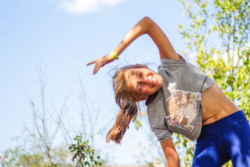 Defocus caucasian preteen girl doing physical exercise in park, forest, outdoor, outside. Slim...