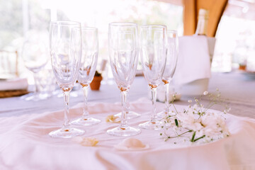 Empty champagne glasses arranged on a tray before a joyous and festive celebration with alcohol.