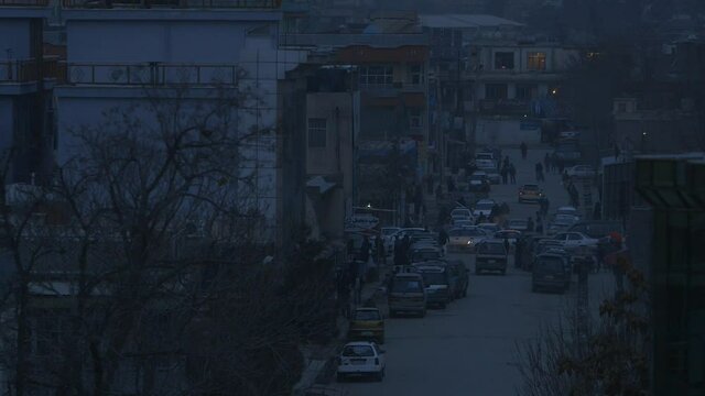 Afghanistan scene - late evening scene from Kabul city - with buildings and  a busy street with traffic and people