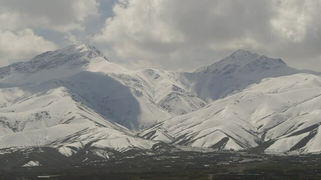 Afghanistan scene - snow filled large mountain range with clouds - outside of Kabul city