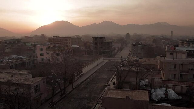 Afghanistan scene - sunrise over Kabul city - wide angle view of street and hills