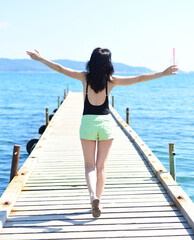 45 years old Russian woman with lemonad running on pier against Japanese sea