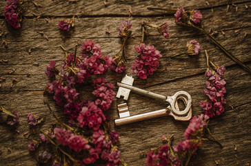 Old key. bunch of flowers on a wooden background
