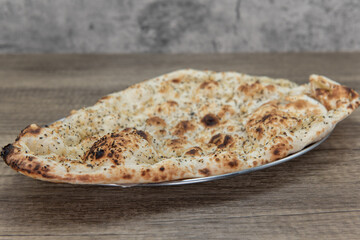 Garlic flavored naan bread from Indian restaurant cooked and seasoned perfectly