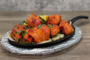 Seasoned chicken served on skillet from Indian restaurant cooked and seasoned perfectly