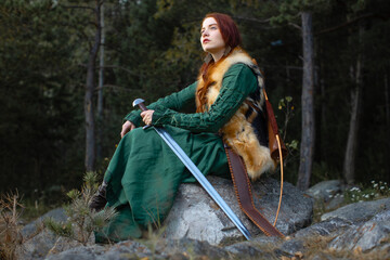 Beautiful red-haired girl-archer of Middle Ages in outdoor. Fantastic concept