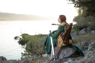 Beautiful red-haired girl-archer of Middle Ages in outdoor. Fantastic concept