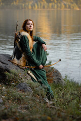 Beautiful red-haired girl-archer of Middle Ages in outdoor. Fantastic concept