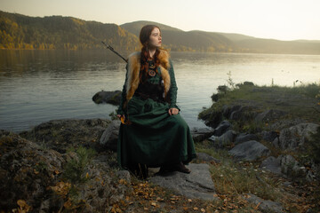 Beautiful red-haired girl-archer of Middle Ages in outdoor. Fantastic concept