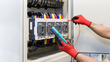 Electrical engineer tests the operation of the electric control cabinet on a regular basis for...