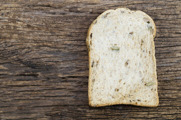 Whole wheat bread slices have rice grain isolated on wood background close up, top view, copy space, breakfast food and drink concept.