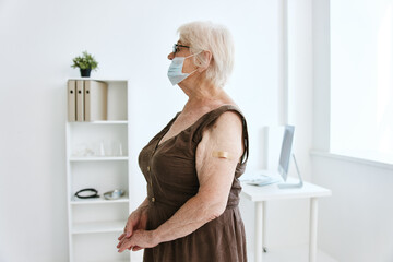 elderly woman plaster on her arm hospital covid-19 vaccination